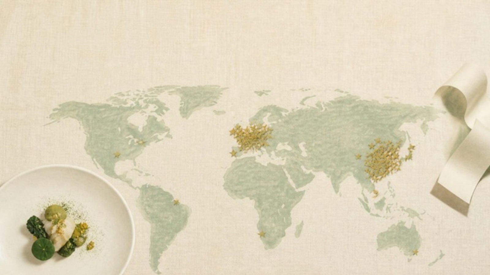 Illustration of a world map spread across a cream table, with clusters of small gold stars over East Asia and Western Europe, a plated course and a paper till receipt.